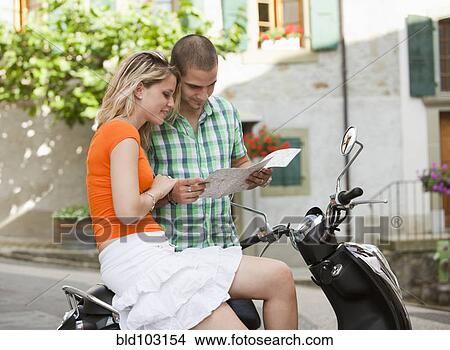 Picture - Couple with scooter looking at map. Fotosearch