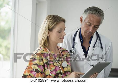 Picture - Doctor and nurse looking at digital tablet. Fotosearch