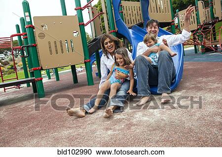 Family sliding down slide on playground View Large Photo Image Stock Image - Family sliding down slide on playground. Fotosearch