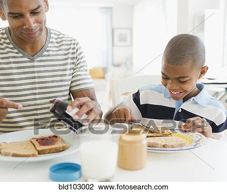 Father and son eating breakfast together View Large Photo Image Stock Image - Father and son eating breakfast together. Fotosearch