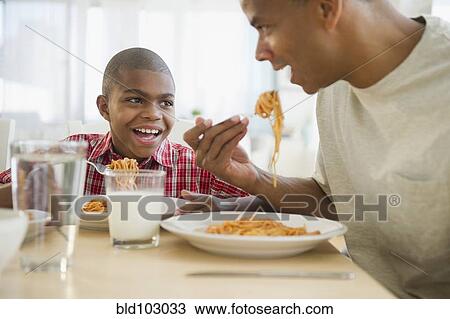 Father and son eating dinner View Large Photo Image Stock Image - Father and son eating dinner. Fotosearch