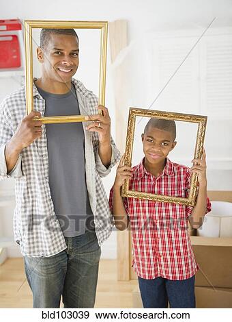 Father and son looking through empty frames View Large Photo Image Stock Photo - Father and son looking through empty frames. Fotosearch