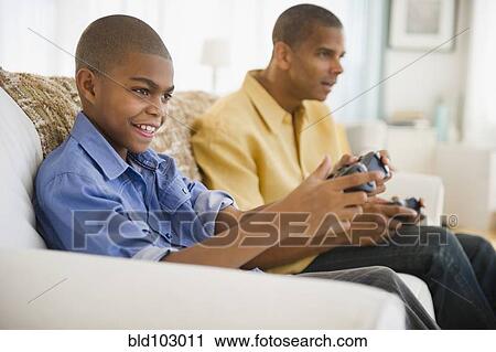 Father and son playing video games View Large Photo Image Stock Image - Father and son playing video games. Fotosearch