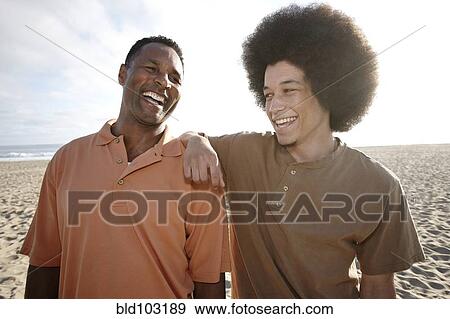 Father and son standing together on beach View Large Photo Image Stock Photo - Father and son standing together on beach. Fotosearch