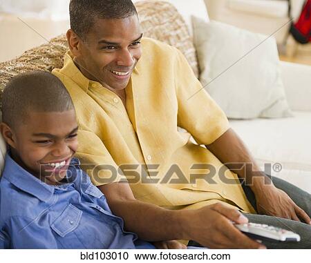 Father and son watching television View Large Photo Image Stock Image - Father and son watching television. Fotosearch