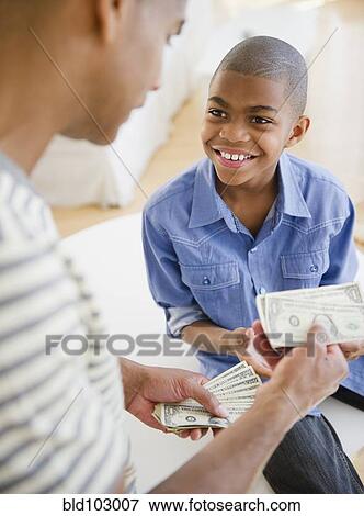 Father giving son money View Large Photo Image Stock Photo - Father giving son money. Fotosearch