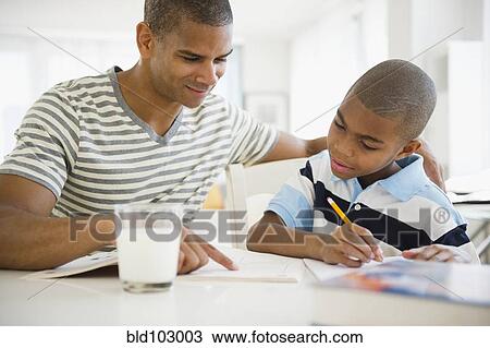 Stock Image - Father helping son with homework. Fotosearch