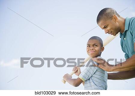 Stock Photo - Father teaching son to play baseball. Fotosearch