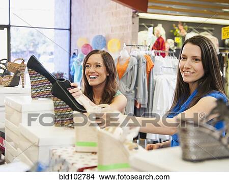Friends shopping for shoes in store View Large Photo Image Picture - Friends shopping for shoes in store. Fotosearch