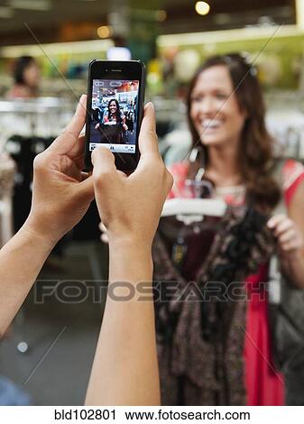 Friends shopping in clothing in store and taking pictures View Large Photo Image Stock Image - Friends shopping in clothing in store and taking pictures. Fotosearch