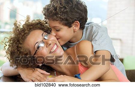 Stock Image - Hispanic boy kissing mother. Fotosearch