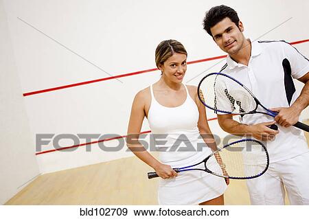 Hispanic couple holding squash racquets View Large Photo Image Stock Photo - Hispanic couple holding squash racquets. Fotosearch