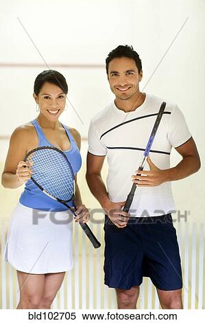 Stock Photography - Hispanic couple holding squash racquets. Fotosearch