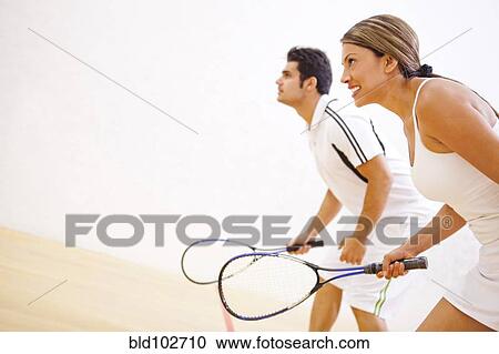 Stock Image - Hispanic couple playing squash. Fotosearch