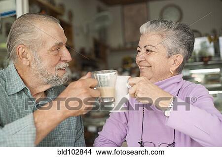 Hispanic couple toasting with coffee cups in cafe View Large Photo Image Picture - Hispanic couple toasting with coffee cups in cafe. Fotosearch