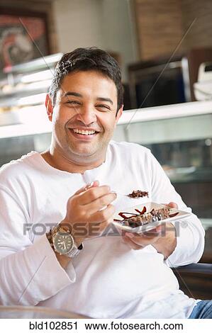 Hispanic man eating dessert in cafe View Large Photo Image Stock Image - Hispanic man eating dessert in cafe. Fotosearch
