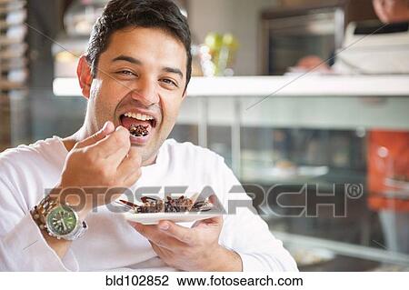 Hispanic man eating dessert in cafe View Large Photo Image Stock Image - Hispanic man eating dessert in cafe. Fotosearch