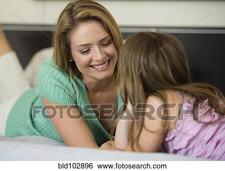 Hispanic mother and daughter laying together View Large Photo Image Stock Photograph - Hispanic mother and daughter laying together. Fotosearch