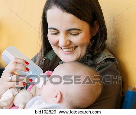 Hispanic mother feeding baby daughter View Large Photo Image Stock Photo - Hispanic mother feeding baby daughter. Fotosearch