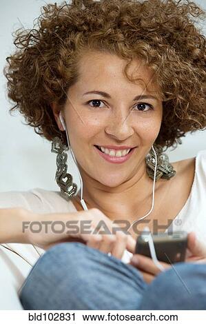 Hispanic woman listening to mp3 player View Large Photo Image Stock Image - Hispanic woman listening to mp3 player. Fotosearch