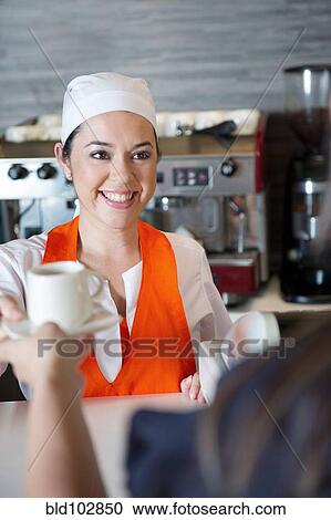 Stock Image - Hispanic woman working in cafe. Fotosearch