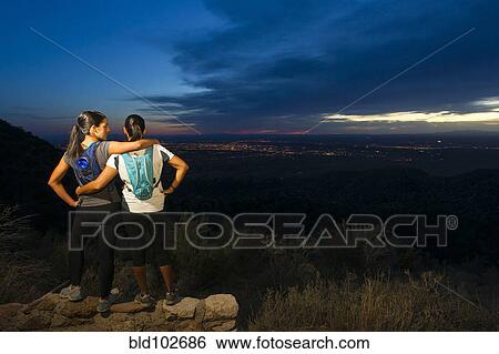 Stock Photograph - Hispanic women backpacking in remote area at night. Fotosearch