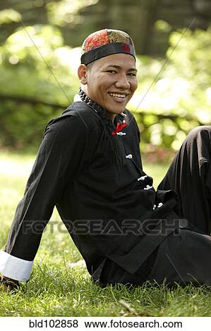 Man in traditional Asian clothing sitting in grass View Large Photo Image Stock Photo - Man in traditional Asian clothing sitting in grass. Fotosearch