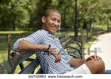 Man sitting on park bench View Large Photo Image Stock Image - Man sitting on park bench. Fotosearch