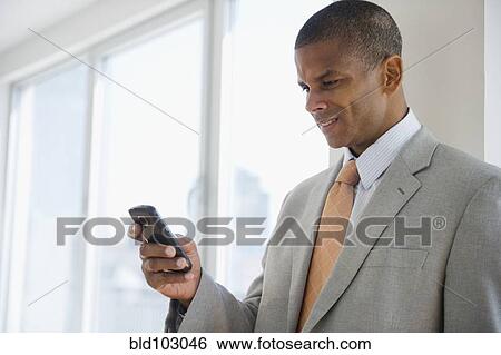 Mixed race businessman text messaging on cell phone View Large Photo Image Stock Photograph - Mixed race businessman text messaging on cell phone. Fotosearch
