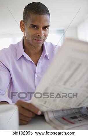 Mixed race man reading newspaper View Large Photo Image Stock Photography - Mixed race man reading newspaper. Fotosearch