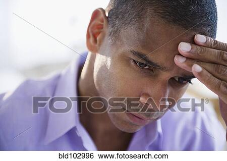 Stock Photograph - Mixed race man with a headache. Fotosearch