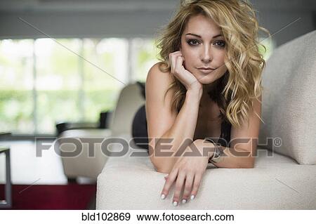 Stock Photo - Sexy Hispanic woman laying on sofa. Fotosearch