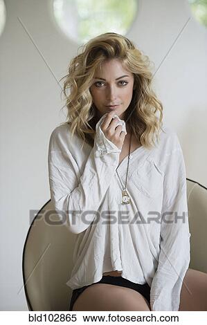 Stock Photography - Sexy Hispanic woman sitting on chair. Fotosearch