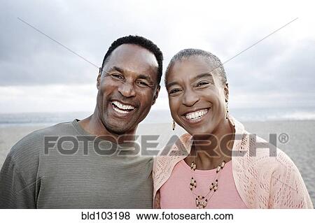 Smiling Black couple on beach View Large Photo Image Stock Photo - Smiling Black couple on beach. Fotosearch