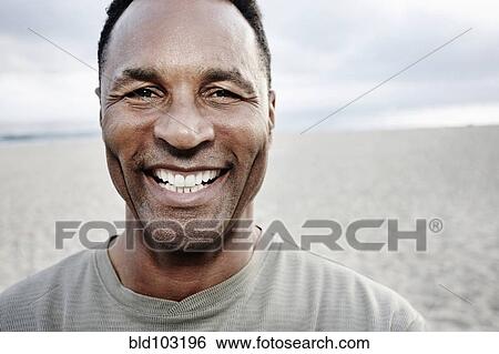 Stock Photograph - Smiling Black man on beach. Fotosearch