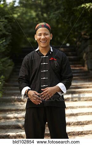 Picture - Smiling man in traditional Asian clothing. Fotosearch