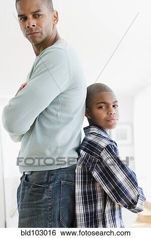 Stock Photograph - Stubborn father and son standing back to back. Fotosearch