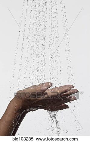 Stock Photography - Woman holding hands under shower. Fotosearch