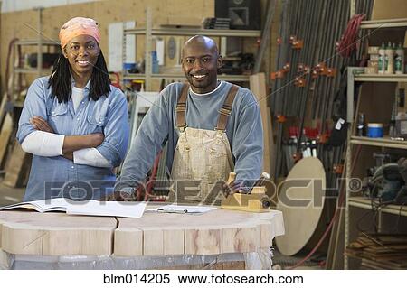 Stock Photography - Black co-workers standing together in factory. Fotosearch
