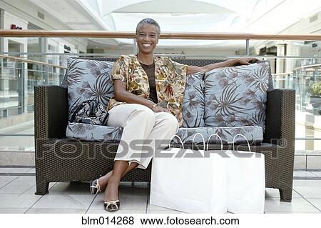 Black woman sitting on sofa in mall with shopping bags View Large Photo Image Stock Photo - Black woman sitting on sofa in mall with shopping bags. Fotosearch