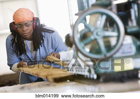 Black worker cutting lumber in factory View Large Photo Image Stock Photo - Black worker cutting lumber in factory. Fotosearch