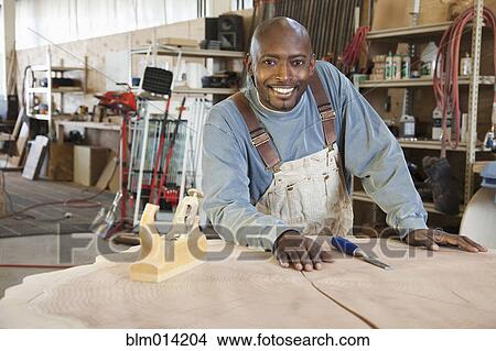 Black worker planing wood in factory View Large Photo Image Picture - Black worker planing wood in factory. Fotosearch