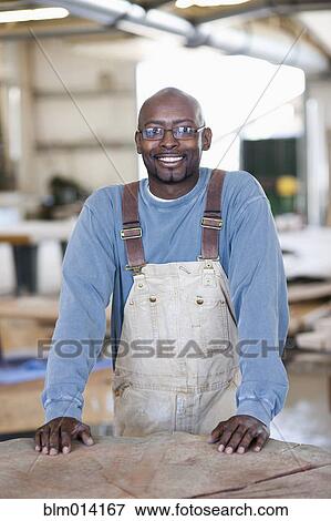 Stock Photo - Black worker standing in factory. Fotosearch