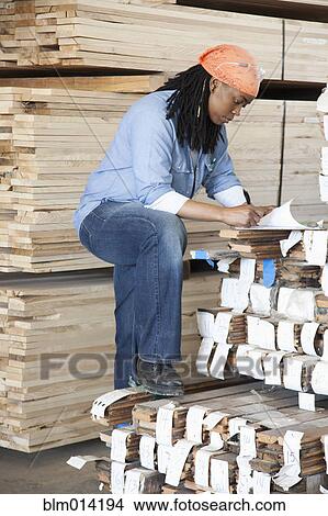 Black worker standing near lumber in warehouse View Large Photo Image Picture - Black worker standing near lumber in warehouse. Fotosearch
