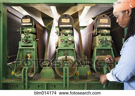 Picture - Black worker using factory machinery. Fotosearch