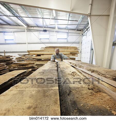 Black worker with lumber in warehouse View Large Photo Image Stock Image - Black worker with lumber in warehouse. Fotosearch
