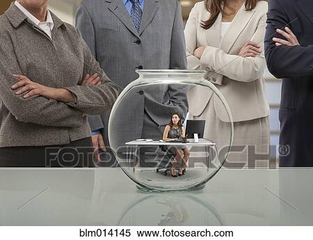 Business people looking at co-worker in fishbowl View Large Photo Image Stock Photography - Business people looking at co-worker in fishbowl. Fotosearch