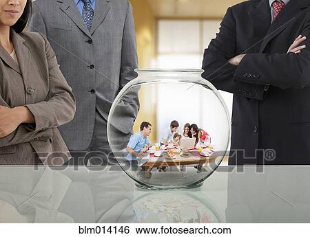 Business people looking at family in fishbowl View Large Photo Image Stock Photograph - Business people looking at family in fishbowl. Fotosearch