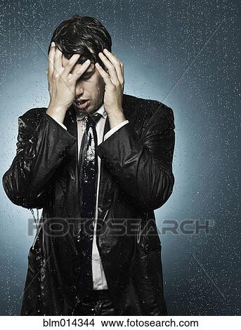 Picture - Caucasian businessman caught in the rain. Fotosearch