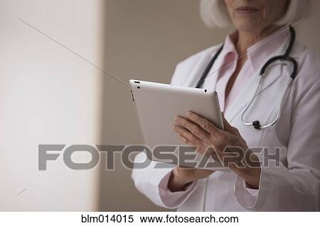 Stock Photography - Caucasian doctor using digital tablet. Fotosearch